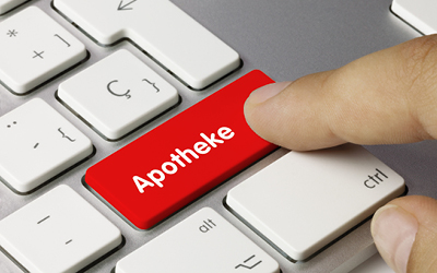 Nahaufnahme einer Tastatur. Ein Finger drückt auf eine rote Taste auf der Apotheke steht